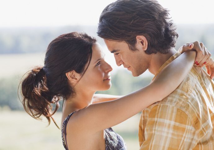 Serious couple hugging outdoors